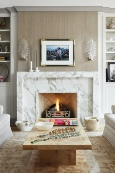 a living room with a fire place in the center and white couches around it