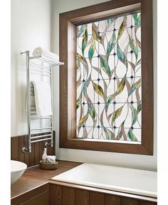 a bathroom with a sink, mirror and bathtub in front of a stained glass window