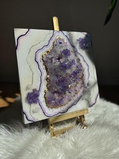 a purple and white painting on an easel