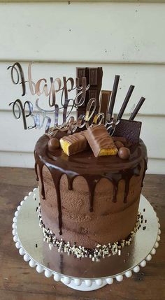 a chocolate birthday cake sitting on top of a wooden table