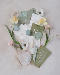 the wedding stationery is laid out on top of each other with flowers and ribbons