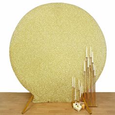 there is a large round gold object on the floor next to some candles and other items