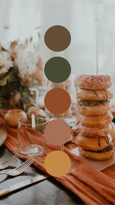 donuts stacked on top of each other at a table with plates and utensils