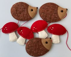 four red and white mushrooms are hanging on the side of a wall, with one mushroom in the middle