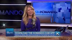 a woman is talking into a microphone in front of a tv screen with the words komando on it