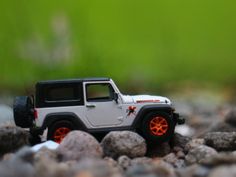 a toy jeep is sitting on some rocks