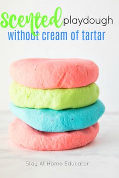 three colorful play doughs stacked on top of each other with text overlay saying, how to make colored playdouies without cream of tartar