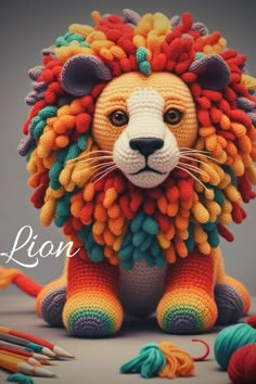 a crocheted lion sitting on top of a table next to yarn and scissors