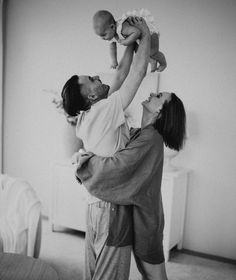 a man holding a baby up in the air