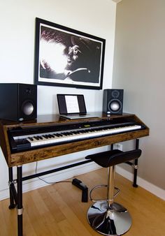 a piano sitting on top of a hard wood floor in front of a framed photo