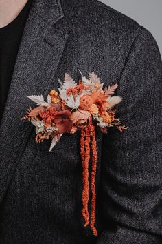 a man in a suit with an orange boutonniere on his lapel