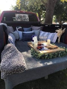 the back end of a pickup truck with pillows and blankets on it's bed