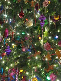 the christmas tree is decorated with colorful ornaments