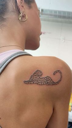 a woman with a cheetah tattoo on her back