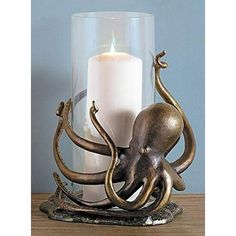 an octopus candle holder on a table next to a lit candle