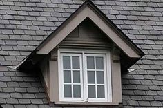 the roof of a house with a window and shingles on it's side