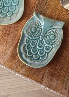 an owl shaped dish sitting on top of a wooden table