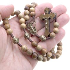 "This long wood cord Catholic rosary is a beautiful and sturdy option for both men and women. The 8mm round beads are made from a brown walnut wood and are strung on a strong cord giving it a rugged and durable feel that is perfect for everyday use.  This rosary is a great Catholic gift, and ships with a drawstring pouch, a unique and personal accessory and an eco-friendly gift box. Features: Length: This rosary necklace is 18 inches long, making it the perfect size for wearing as a necklace or Rosary Beads Catholic, Cary Nc, Catholic Rosary, Rosary Necklace, Hail Mary, Rosary Catholic, Rosary Beads, Catholic Gifts, Drawstring Pouch