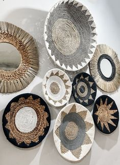 several woven baskets are arranged on a white surface, each with different designs and sizes