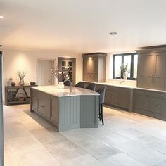 a large open kitchen with an island in the middle and lots of cabinets on either side