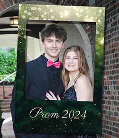 a man and woman are posing in front of a brick wall with the words prom written on it