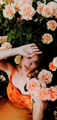 a woman in an orange dress surrounded by flowers