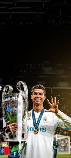 the soccer player is posing with his trophy