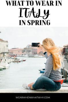 a woman sitting on the edge of a pier taking a photo with her camera text reads what to wear in italy in spring