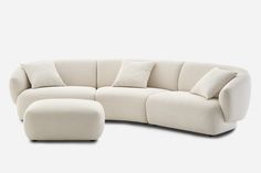 a white couch and ottoman with pillows on it