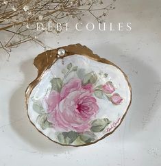 a pink rose painted on a white and gold plate with the words beth coulies above it