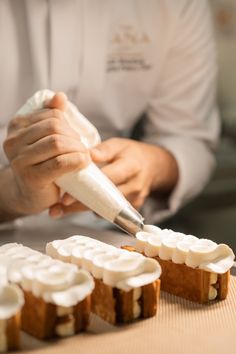 a chef is decorating small cakes with icing