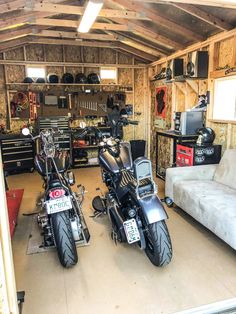 two motorcycles are parked in a garage next to a couch