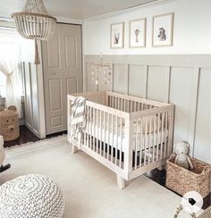 a baby's room with a white crib and some pictures on the wall