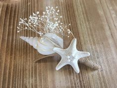 two starfishs are sitting next to each other on a wooden table with shells