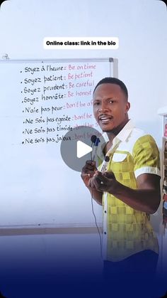 a man standing in front of a whiteboard holding a microphone and giving a speech