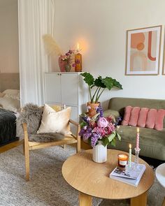 a living room filled with furniture and flowers on top of a table in front of a couch