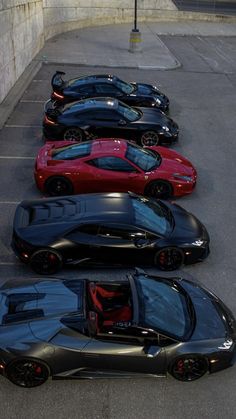 a row of black and red sports cars parked in a parking lot