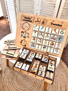 a wooden board game sitting on top of a rug next to a table filled with cards