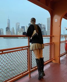 a woman standing on the side of a boat looking at the water