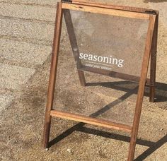 a wooden sign sitting on top of a sidewalk