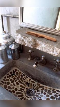 a bathroom sink with a wooden brush on top of it