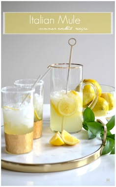 two glasses filled with lemonade on top of a white plate next to some lemons