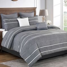 a bed with grey and white striped comforter