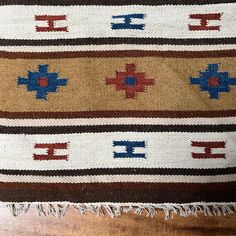 a brown and blue rug on top of a wooden floor