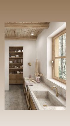 a kitchen with two sinks and wooden cabinets in it's center area, next to a window