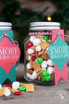 two mason jars filled with holiday treats on top of a table