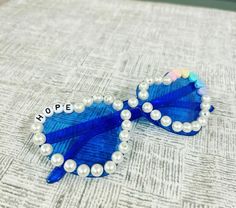 a pair of blue sunglasses with pearls and hope written on the side sitting on a table