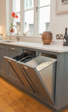 an open dishwasher sitting on top of a kitchen counter