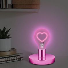 a pink heart shaped light sitting on top of a table