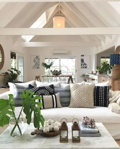 a living room filled with lots of furniture next to a white table and ceiling fan